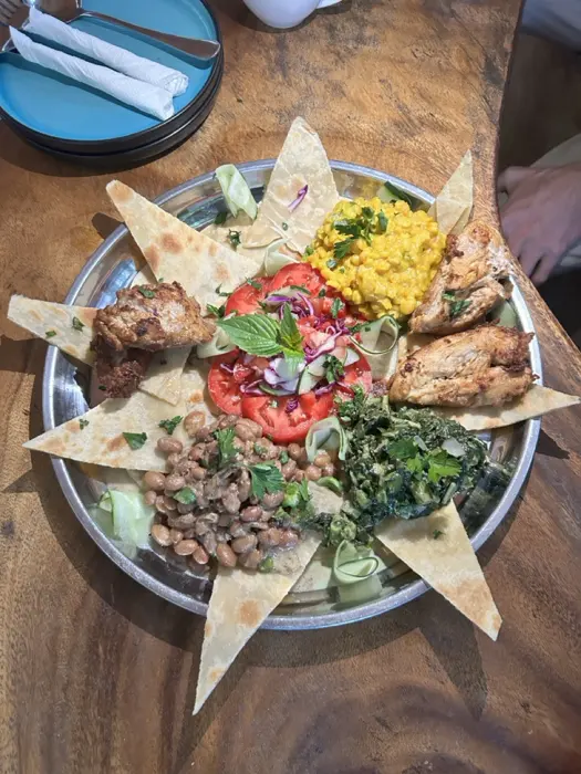 Pamoja platter with chapati, chicken, beans, dhal, greens and tomato salad