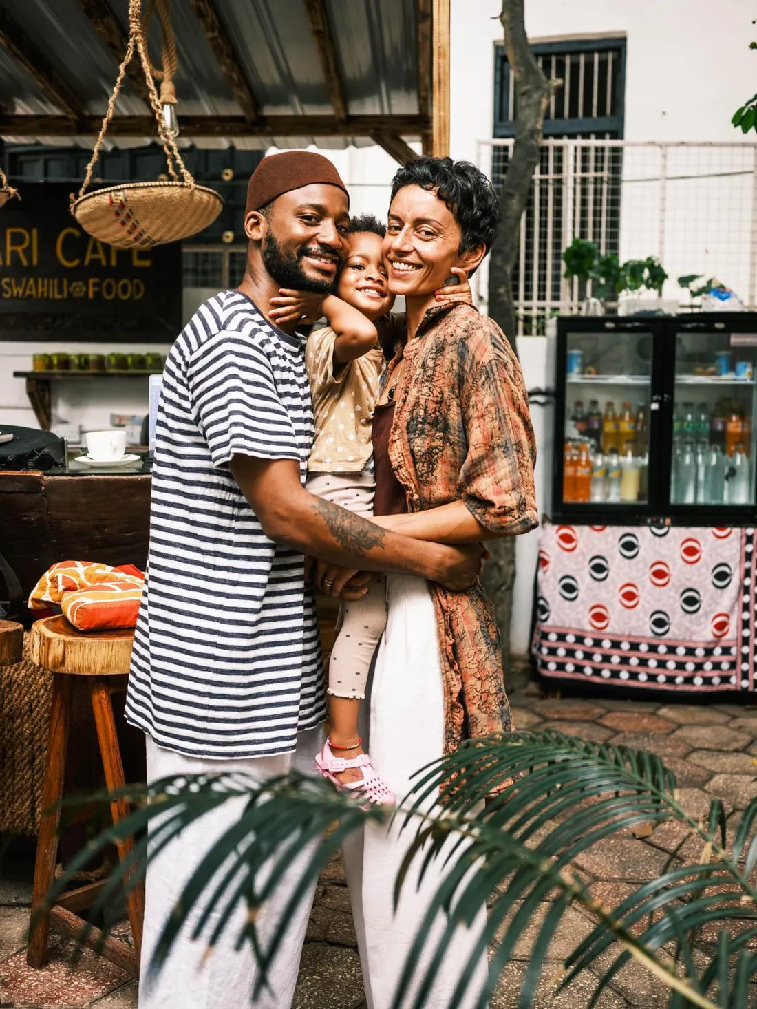 GG, Lucy and their daughter Loloma smiling together in the Habari Café garden
