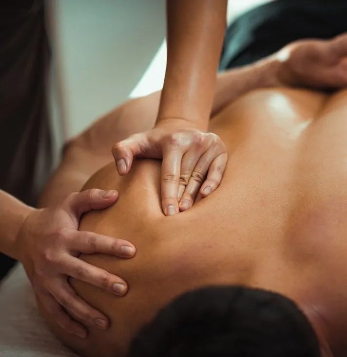 Therapist massaging a client's shoulder and upper back