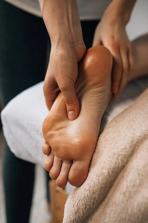 Therapist massaging the sole of a client's foot