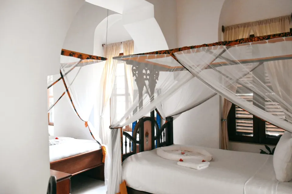 Zambarau Family Room with two four-poster beds under mosquito nets