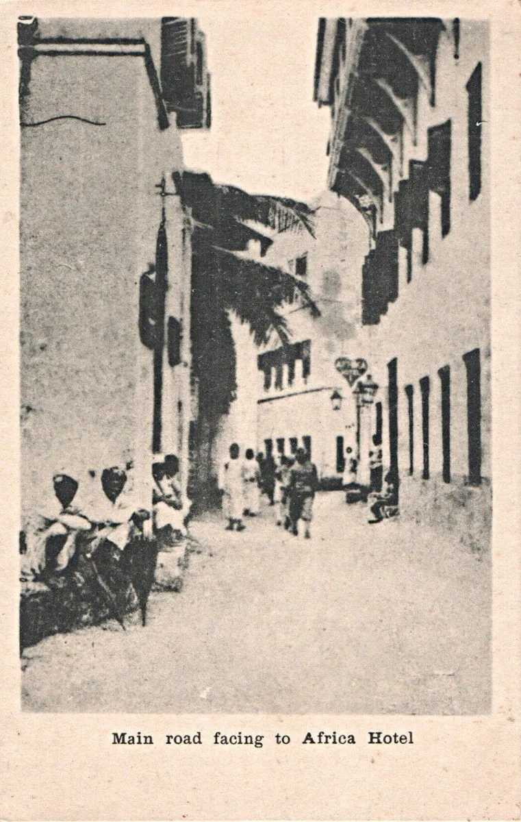 Vintage photo of a Stone Town street with people sitting along the walls