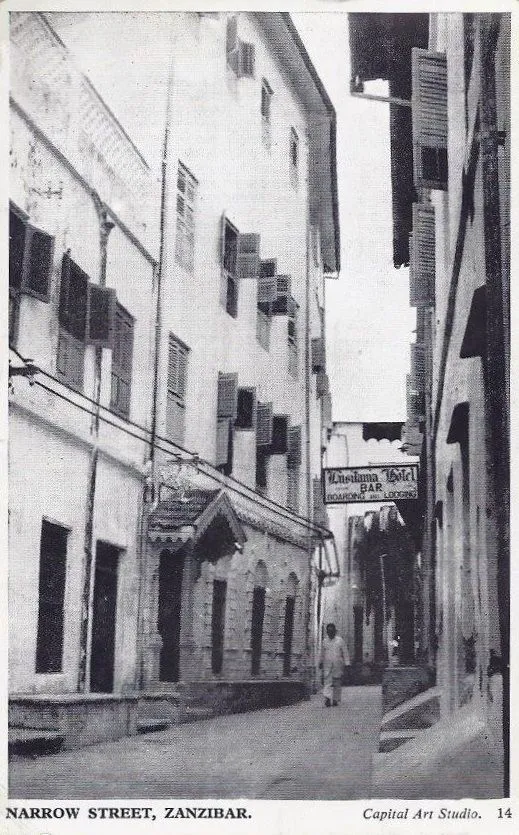 Vintage photo of a narrow street between tall shuttered buildings